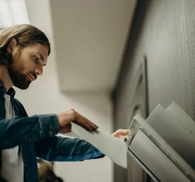 Medewerker haalt afgedrukte documenten uit printer bij Machelp